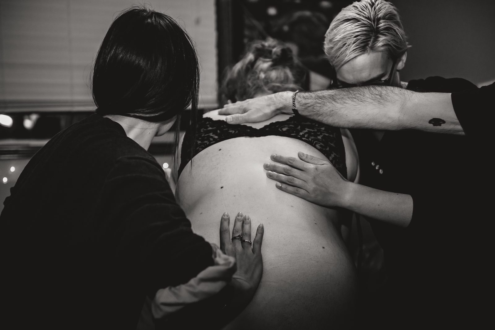 A doula offering hands-on comfort and steady support to a labouring person.